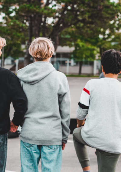 3 drenge står med ryggen til og ser på en anden dreng som laver boldtriks